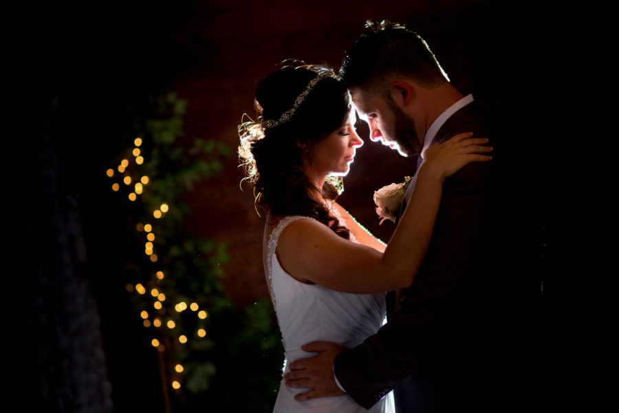 Bride & Groom embrace in a beautiful backlit portrait on their wedding day at the Cooper House in Conway, SC. 