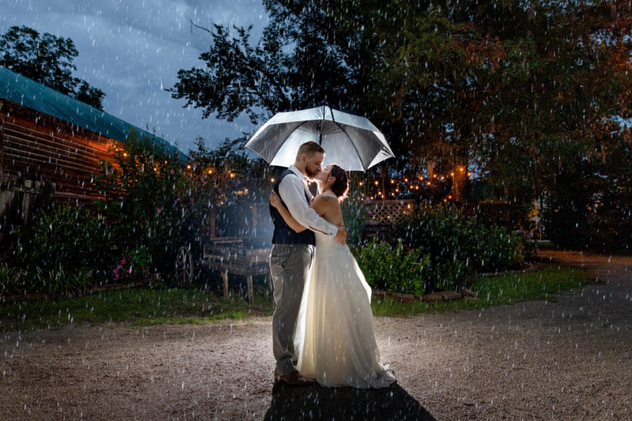 Bride & Groom kiss in the rain at their Cooper House wedding. 