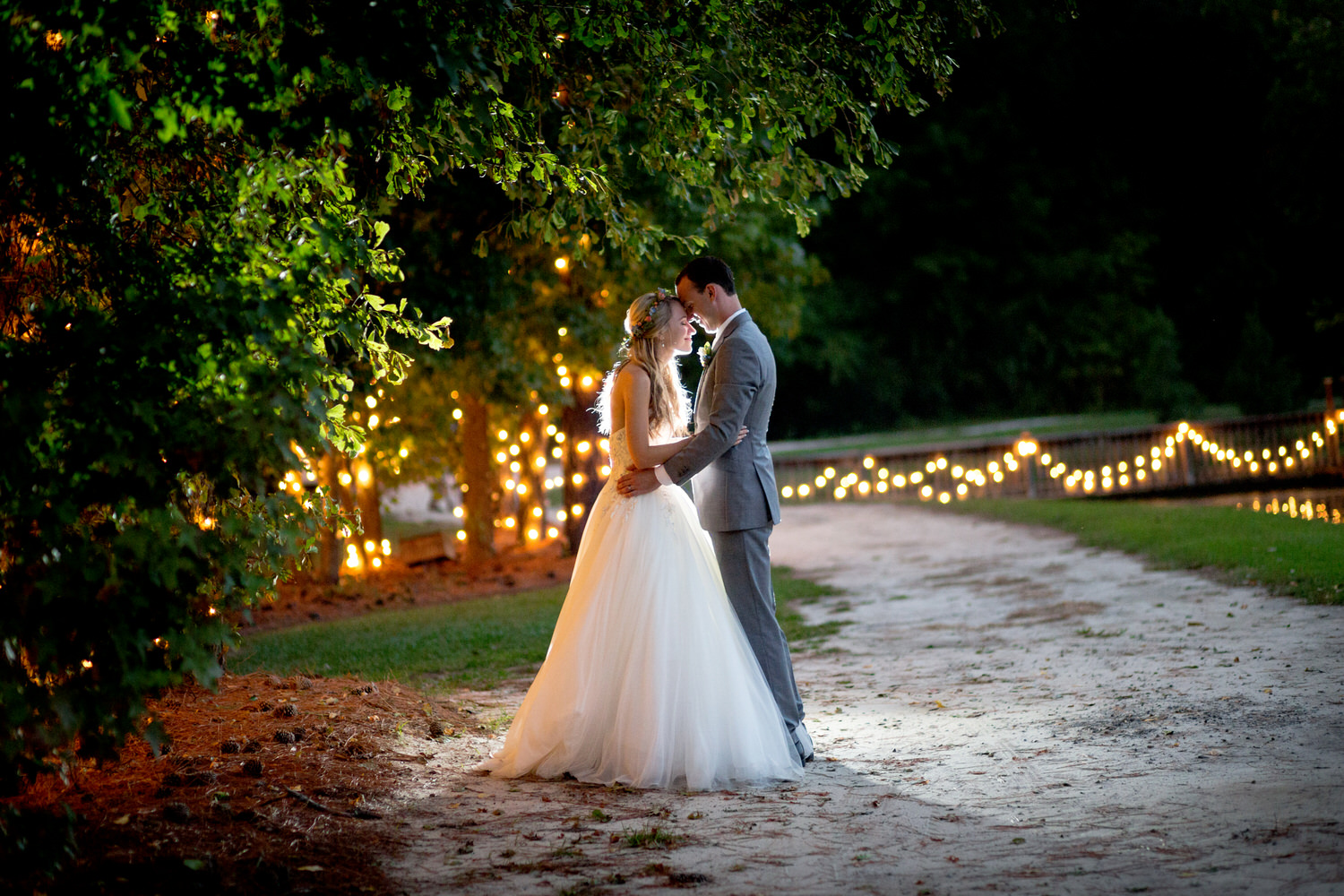 Beautiful backlit image of a bride & groom in front of the twinkle lights at Hidden Acres in Marion, SC. 