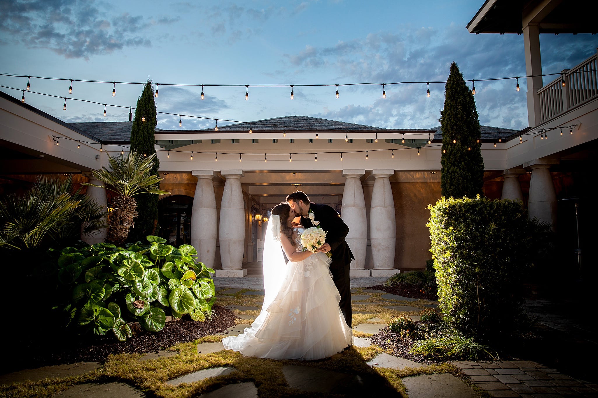 A bride & groom kiss on their wedding day in the courtyard of 21 Main Events. 