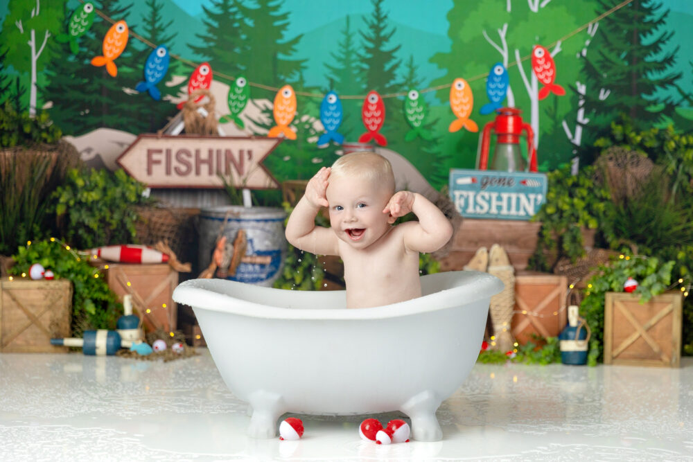 Baby boy plays in the tub at his first birthday "o-fish-ally one" photo session at the Crystal Lee Photography studio in Myrtle Beach, SC 